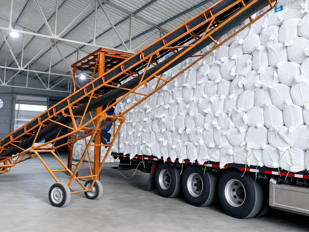 Finished ceramic fiber blanket bulk bags being loaded onto truck by conveyor in factory warehouse